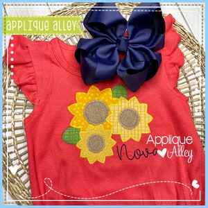 Puede incluir: Una camiseta roja para niños pequeños con una aplicación de girasol y el texto "Applique Nova Alley" en negro con un corazón.
