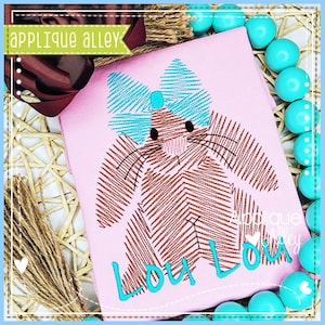 May include: A pink shirt with an embroidered brown bunny wearing a blue bow. The bunny has a pink nose and whiskers. The name "Lou Lou" is embroidered in turquoise below the bunny.