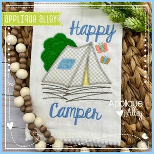 May include: White camping-themed towel with embroidered text reading "Happy Camper." The design includes a tent, tree, and butterflies. The towel has a pom-pom trim and the words "Applique Alley" are also embroidered.