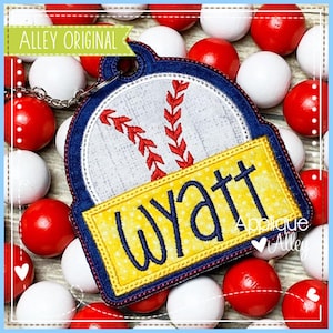 May include: A blue and yellow baseball-themed personalized keychain with the name Wyatt. The keychain features a white baseball with red stitching and a yellow name tag.