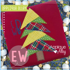May include: A red fabric item with an appliqued Christmas tree design. The tree features yellow, green, and plaid triangle shapes. The text "Applique Alley" and initials are visible. The design is on a red background.