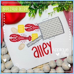 May include: White fabric with a red and gray crawfish boil design. The design includes two red crawfish, yellow crackers, and the word "alley" in red. The brand name "Applique Alley" is also visible.