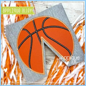 May include: A gray felt applique of a basketball with orange and black stitching. The basketball is cut out in a wedge shape. The applique is on a gray background.