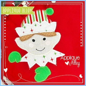 May include: A red fabric elf applique with a white hat featuring green and red stars and stripes. The elf has a smiling face, green hands, and the text "Applique Alley".