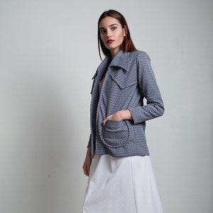 May include: A woman wearing a white skirt and a blue and white patterned jacket. She is wearing cork platform heels.