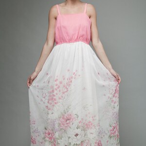 May include: A pink and white maxi dress with a floral print. The dress has a fitted bodice and a flowing skirt.