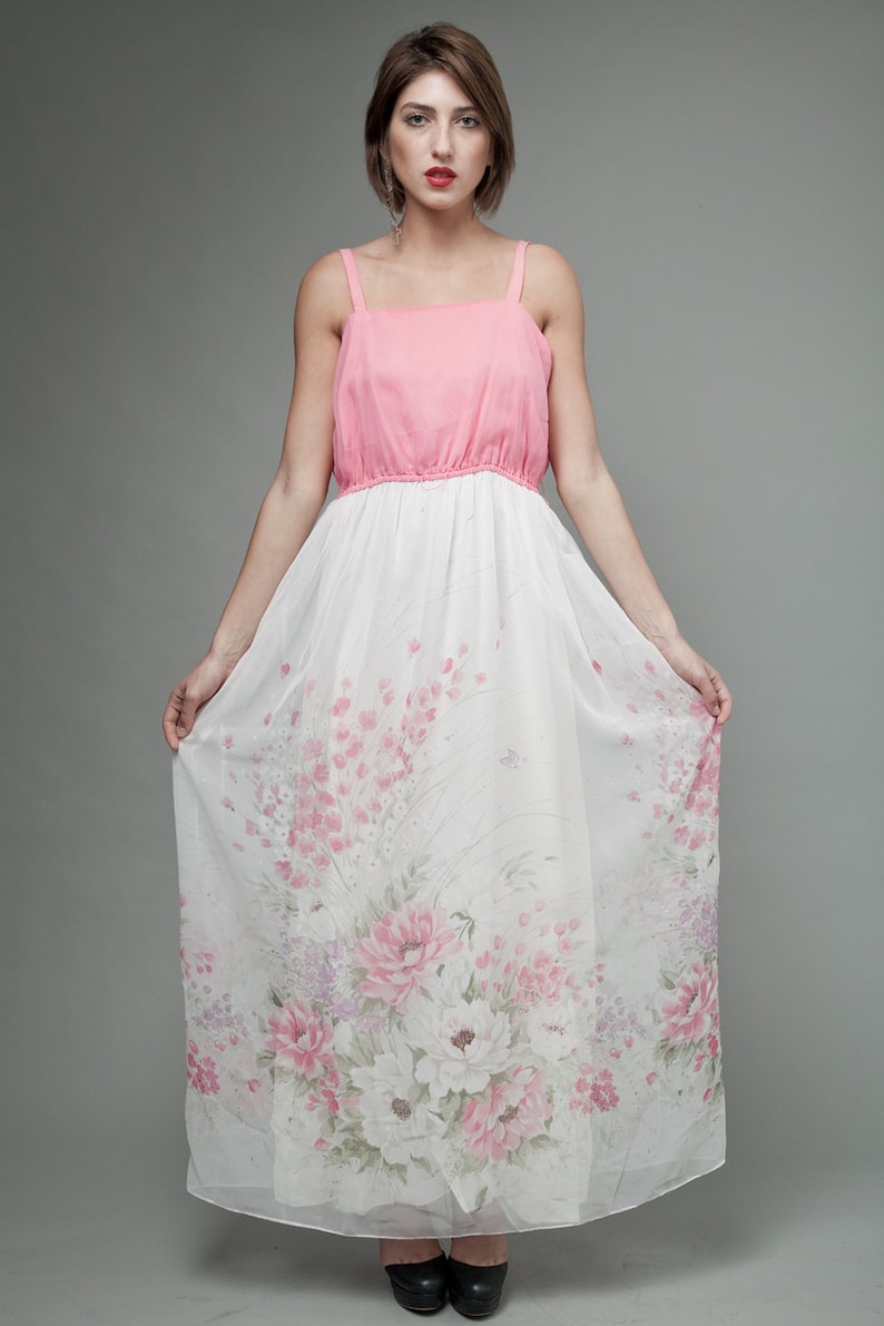 May include: A pink and white maxi dress with a floral print. The dress has a fitted bodice and a flowing skirt.