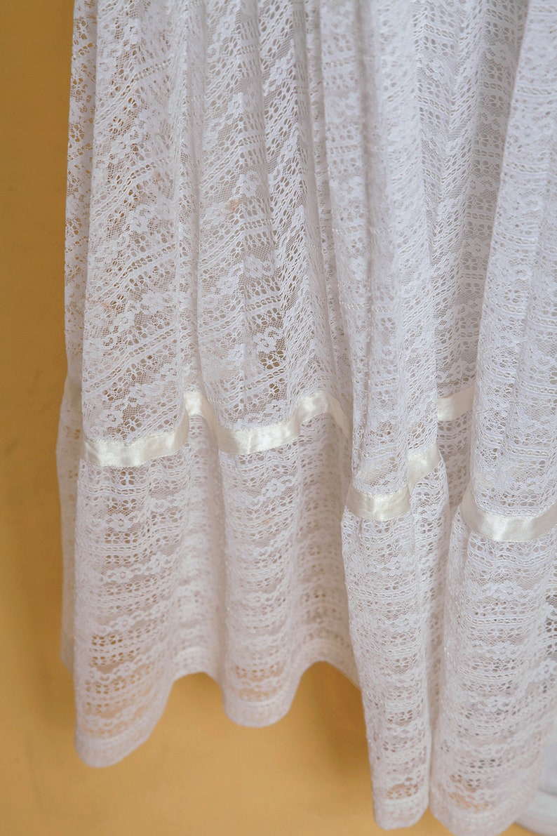 Puede incluir: Falda de encaje blanco con tres filas de cinta de sat&eacute;n. La falda est&aacute; hecha de encaje delicado y transparente y tiene un estilo fluido y rom&aacute;ntico.