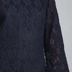 May include: A navy blue lace top with a boat neck and three-quarter sleeves.