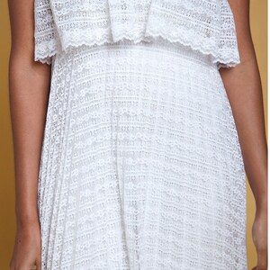 Puede incluir: Vestido blanco maxi sin tirantes con un corpi&ntilde;o de encaje y una falda plisada.