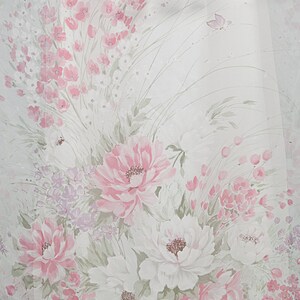 May include: White fabric with a pink floral pattern. The flowers are painted in shades of pink and white, with green leaves and stems. There are also small pink flowers scattered throughout the fabric.