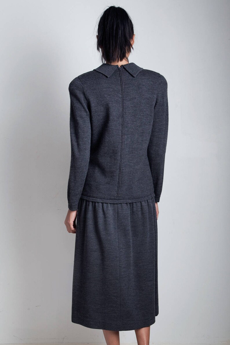 May include: A charcoal gray knit dress with a collared neckline and a long skirt. The dress has a zipper down the back.