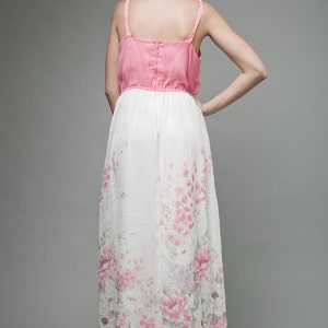 May include: A pink and white maxi dress with a floral print. The dress has a fitted bodice and a flowing skirt.