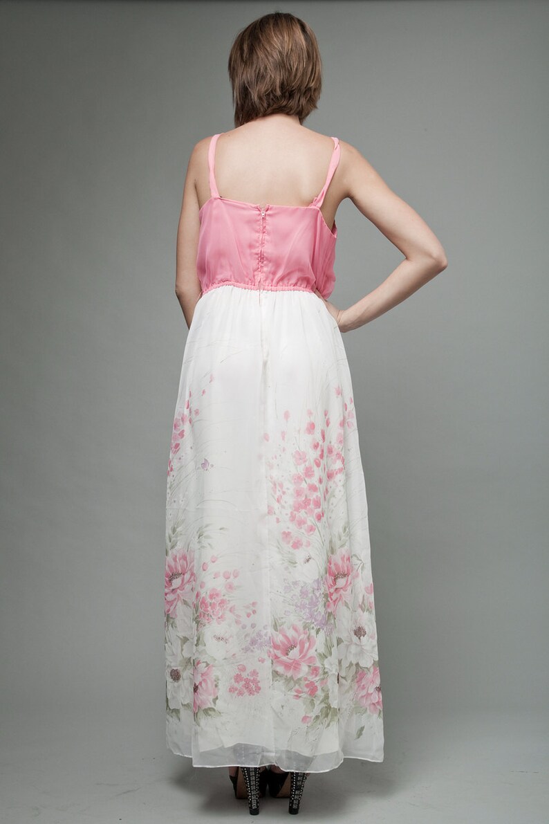 May include: A pink and white maxi dress with a floral print. The dress has a fitted bodice and a flowing skirt.
