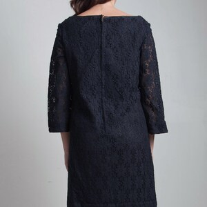 May include: A black lace dress with a scoop neckline and 3/4 sleeves.