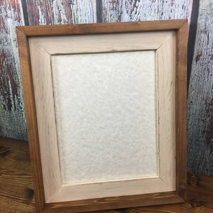 May include: A rustic wooden picture frame with a whitewashed inner frame. The frame is made of natural wood with a brown stain and has a distressed look.