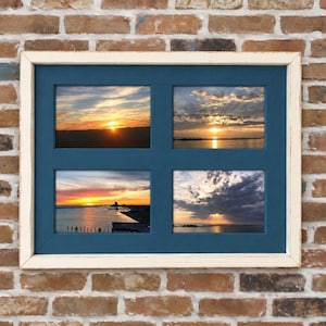 May include: A rectangular collage picture frame with a distressed white outer border and a dark blue matting. The frame holds four separate landscape-oriented photographs, each depicting a sunset over a body of water with clouds in the sky.