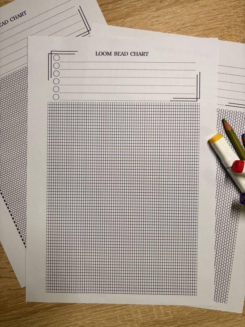 Puede incluir: Varias hojas de papel blanco "LOOM BEAD CHART" con un patr&oacute;n de cuadr&iacute;cula y l&iacute;neas punteadas. Las hojas est&aacute;n sobre una superficie de madera, con l&aacute;pices de colores y un borrador en el fondo. La cuadr&iacute;cula est&aacute; hecha de l&iacute;neas finas de color azul oscuro.