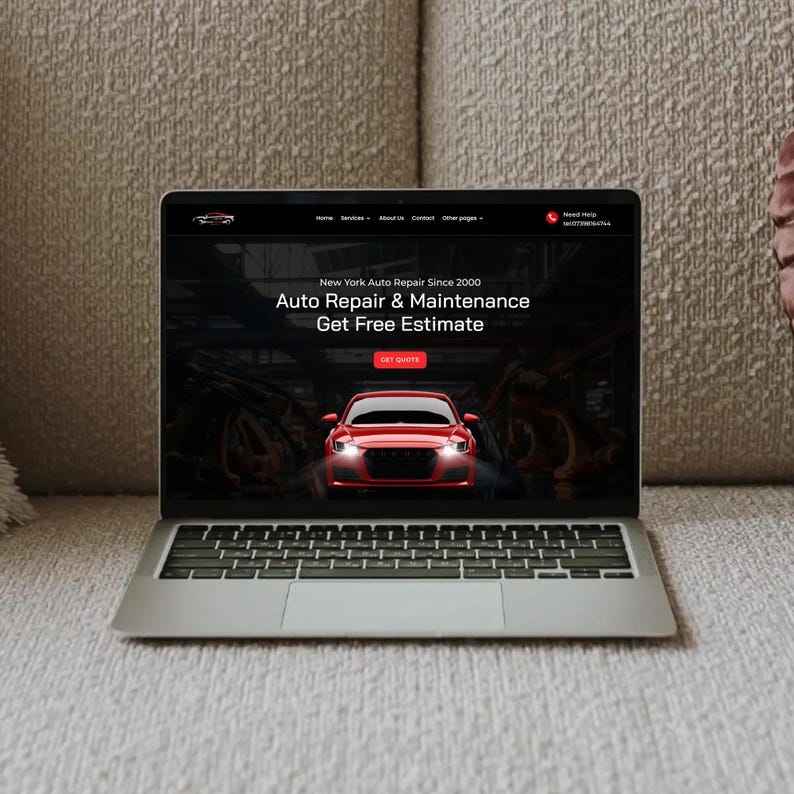 May include: A silver laptop displaying a website for New York Auto Repair. The website features a red car graphic and the text "Auto Repair & Maintenance". The laptop is resting on a beige sofa.