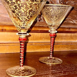 May include: A white ceramic mug with a black handle and the text "But First, Coffee" in a handwritten style. The mug is on a white surface. The mug is 4 inches tall.