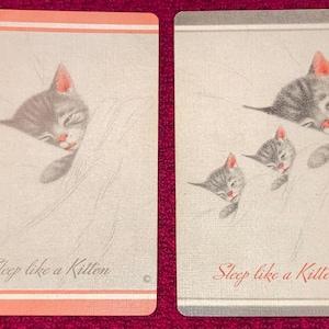 Puede incluir: Dos tarjetas rectangulares con ilustraciones de gatitos durmiendo. Una tarjeta tiene un borde rosa, la otra gris. El texto "Sleep like a Kitten" est&aacute; impreso en cada tarjeta.