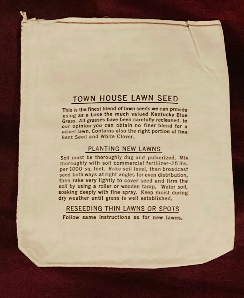 May include: A white paper bag with black text that reads "Town House Lawn Seed". The bag contains instructions for planting new lawns and reseeding thin lawns or spots. The instructions include using 25 pounds of fertilizer per 1000 square feet.