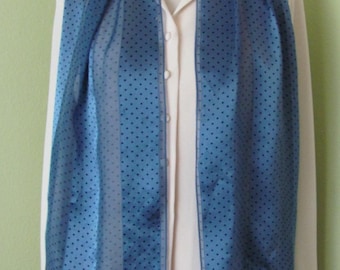 May include: A blue and white polka dot scarf with a black trim. The scarf is made of a sheer fabric and is perfect for adding a touch of elegance to any outfit.