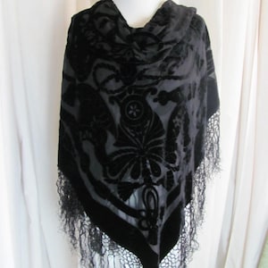 Puede incluir: Chaleco de terciopelo negro con un patrón floral y ribete de flecos.