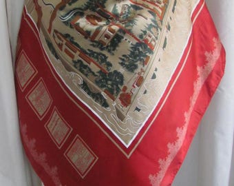 May include: A red silk scarf with a beige and brown print of a Chinese garden scene. The scarf has a white border and a gold and red border with a decorative design.