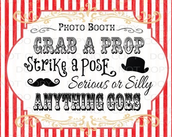 May include: A white sign with black text that says "Photo Booth", "Grab a Prop", "Strike a Pose", "Serious or Silly", and "Anything Goes". The sign has a red and white striped background.
