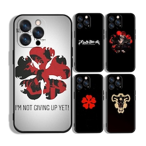 Peut inclure: Plusieurs coques de téléphone avec des motifs de l'anime Black Clover. Les designs incluent un trèfle à quatre feuilles, des illustrations de personnages et le texte "I'M NOT GIVING UP YET!".