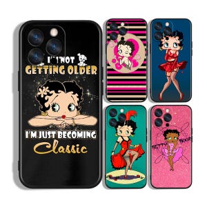 May include: A selection of phone cases with Betty Boop illustrations. The cases display the cartoon character in diverse poses and attire. One case features the text "I'M NOT GETTING OLDER I'M JUST BECOMING Classic".
