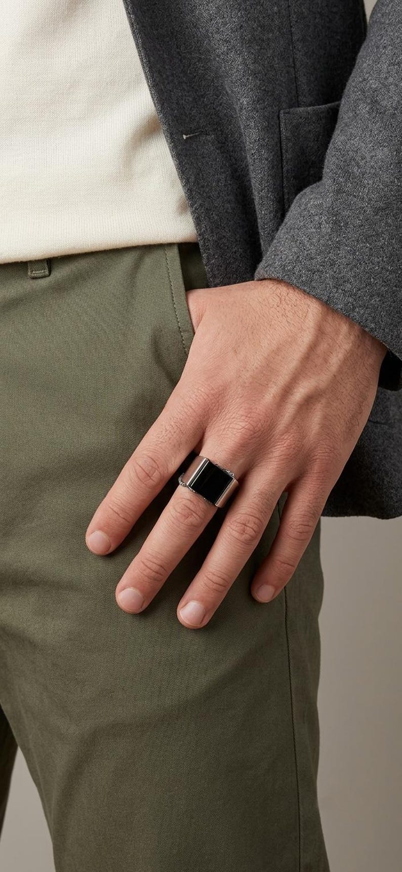 May include: A wide silver-toned metal ring featuring a smooth, rectangular black inlay centered on the band. The ring has a polished finish and a flat top surface, showcasing a clean, geometric design that sits prominently on the finger.