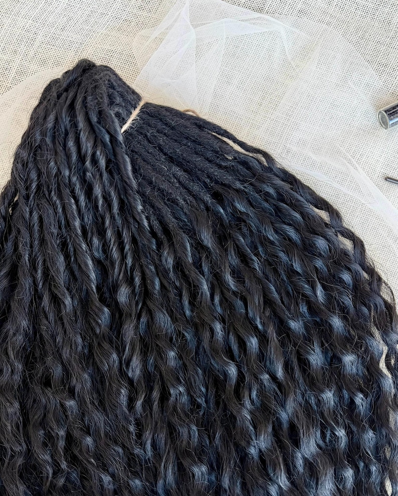 May include: A bundle of black synthetic hair extensions featuring a tight, twisted, and wavy texture. The strands are gathered at the top with a thin, light-colored cord, creating a uniform arrangement of long, dark, and voluminous hair pieces.