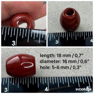 May include: A glossy, dark red, barrel-shaped bead with a central hole. The bead measures 18 mm or 0.7 inches in length, 16 mm or 0.6 inches in diameter, and features a hole size of 5-6 mm or 0.3 inches, as indicated by the visible ruler.