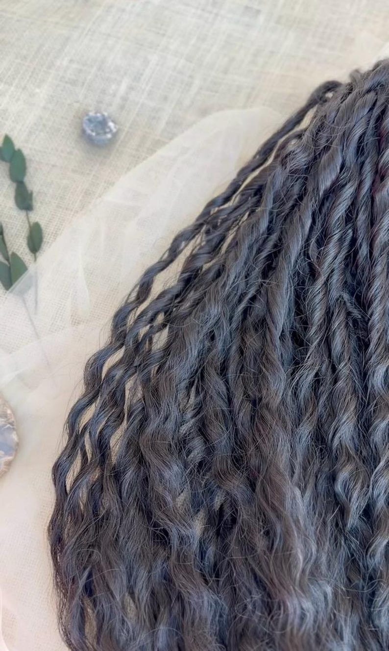 May include: A collection of dark charcoal gray hair extensions featuring a tight, twisted, and wavy texture. The individual strands are bundled together, showcasing a consistent deep gray color throughout the length of the wavy, coiled hair pieces.