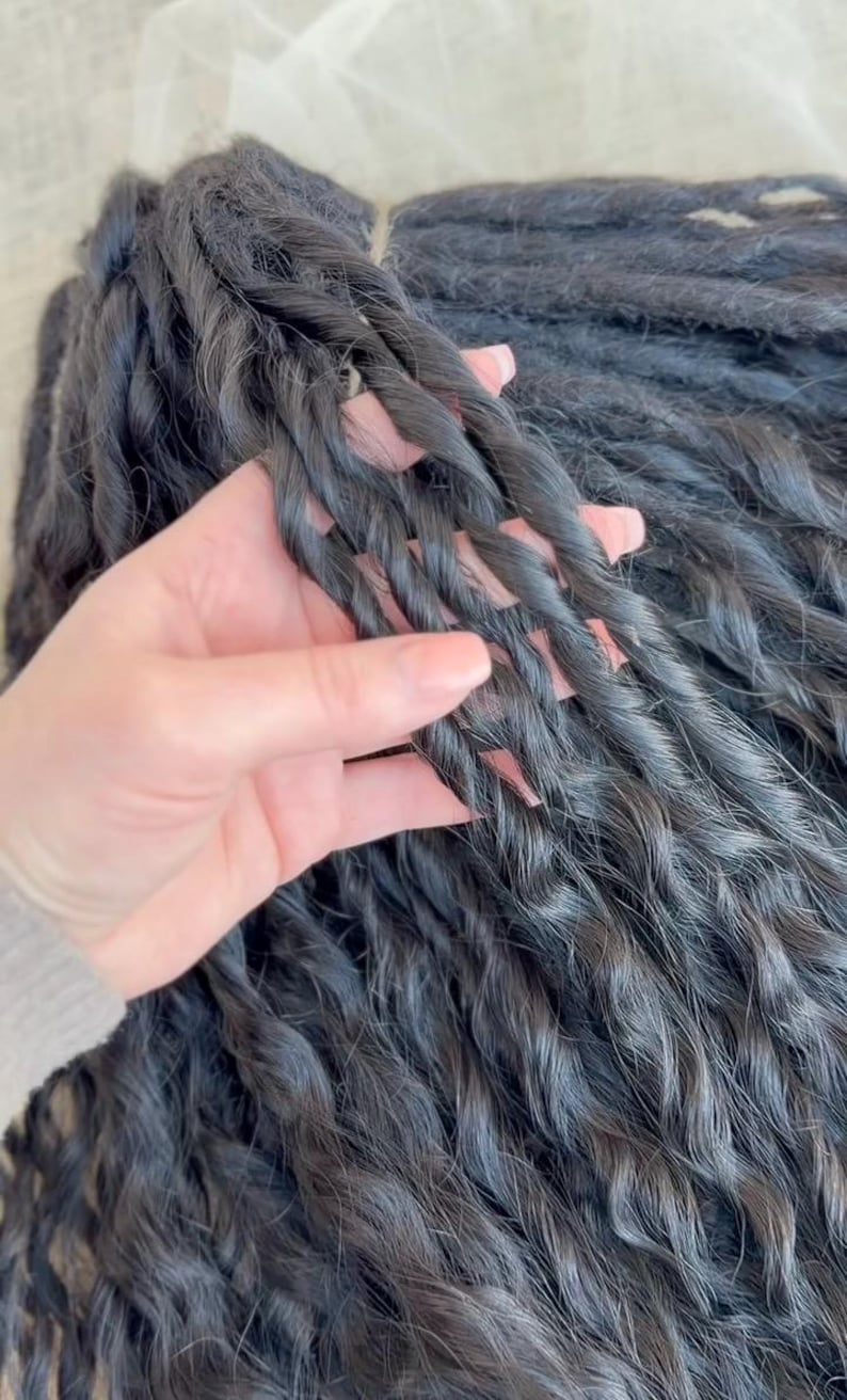 May include: A collection of long, dark black hair extensions styled into tight, uniform twists. The individual strands are bundled together, showcasing a consistent, textured, and spiraled appearance throughout the length of the hair pieces.