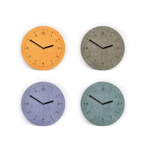 Könnte beinhalten: Vier runde Wanduhren in Orange, Grau, Lila und Türkis. Jede Uhr hat schwarze Zeiger und Zahlen. Die Uhren befinden sich auf weißem Hintergrund. Die Uhren sind ein dekorativer Artikel.