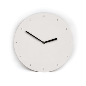 Könnte beinhalten: Eine minimalistische weiße Wanduhr mit schwarzen Zeigern und Ziffern. Das Zifferblatt ist schlicht weiß, mit den Zahlen 1 bis 12. Die Zeiger sind schwarz, und die Uhrzeit ist ungefähr 2:50 Uhr. Der Durchmesser beträgt etwa 25 cm.