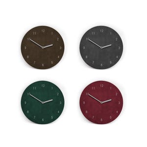 Könnte beinhalten: Vier runde Wanduhren in verschiedenen Farben: Braun, Dunkelgrau, Grün und Burgunderrot. Jede Uhr hat weiße Zeiger und weiße Zahlen. Die Uhren sind in einer quadratischen Formation vor einem weißen Hintergrund angeordnet. Durchmesser ca. 25 cm.