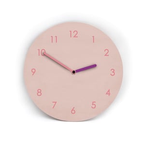 Könnte beinhalten: Eine runde Wanduhr mit einem blassrosa Zifferblatt und passenden rosa Zahlen von eins bis zwölf. Die Uhr hat einen langen rosa Minutenzeiger, der auf die zehn zeigt, und einen kürzeren violetten Stundenzeiger, der auf die zwei zeigt.