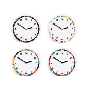 Könnte beinhalten: Vier runde Wanduhren mit weißen Zifferblättern und schwarzen Zeigern. Jede Uhr hat einen anderen bunten, gemusterten Rand. Die Zahlen sind schwarz. Die Uhren befinden sich auf weißem Hintergrund.