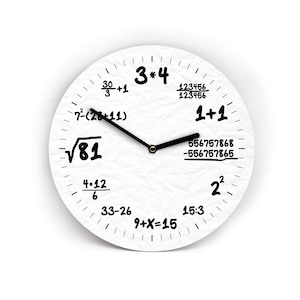 Könnte beinhalten: Weiße, runde Wanduhr mit schwarzen Zeigern und Zahlen. Die Zahlen sind durch mathematische Gleichungen ersetzt. Das Zifferblatt hat eine strukturierte, papierartige Oberfläche. Einzigartige und lehrreiche Wohnkultur.
