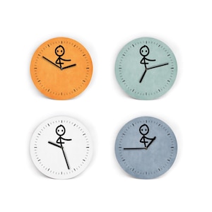Könnte beinhalten: Vier runde Wanduhren mit minimalistischem Strichmännchen-Design. Jede Uhr hat ein andersfarbiges Zifferblatt: Orange, Blaugrün, Weiß und Blaugrau. Die schwarzen Zeiger und das Strichmännchen verleihen den Uhren eine verspielte Note.