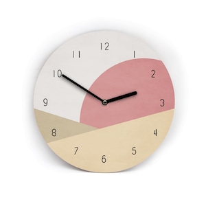 Könnte beinhalten: Eine runde Wanduhr mit minimalistischem Design. Das Zifferblatt ist in Abschnitte aus Weiß, Rosa und Beige unterteilt. Schwarze Zeiger zeigen auf die Zahlen 1 bis 12. Die Uhr hat eine moderne, abstrakte Ästhetik.