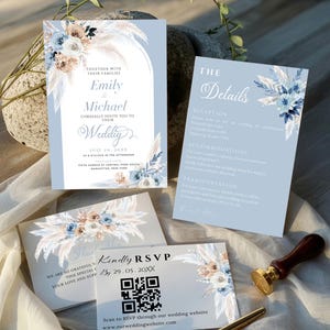 Peut inclure: Ensemble de papeterie de mariage dans les tons de bleu, beige et blanc. L'invitation, la carte de détails, la carte RSVP et la carte de remerciement présentent des motifs floraux et de pampas. Un stylo doré et un sceau de cire sont également présents.