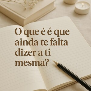 Op de afbeelding: Een open notitieboek met gelinieerde pagina's en een zwarte pen erop. Het notitieboek is open op een pagina met de tekst "O que é é que ainda te falta dizer a ti mesma?" geschreven in bruin lettertype.