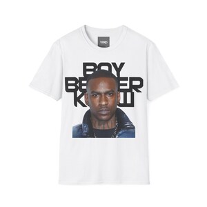 May include: White t-shirt with a portrait of a man and the text "BOY BETTER KNOW" in black. The man is wearing a blue jacket and a silver chain. The shirt has a crew neck and short sleeves.