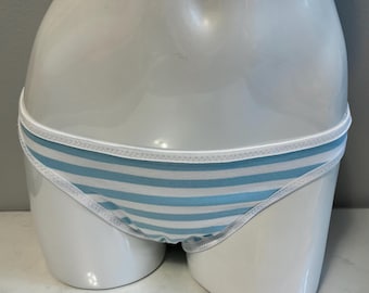 May include: A pair of bikini-style underwear featuring horizontal light blue and white stripes. The garment is finished with a solid white elastic waistband and matching white trim along the leg openings, displayed on a smooth white mannequin.
