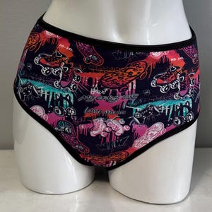 May include: Black underwear with a colorful print of roller skates, graffiti, and the text "My crazy life Love Music".